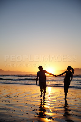 Buy stock photo Silhouette image of a couple walking and holding hands at sunrise