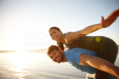 Buy stock photo Shot of a couple pretending to fly on the beach at sunrise