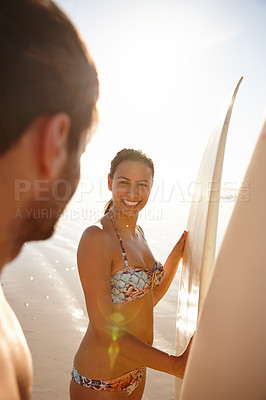 Buy stock photo Shot of a happy young woman smiling with her boyfriend and their surfboards at the beach