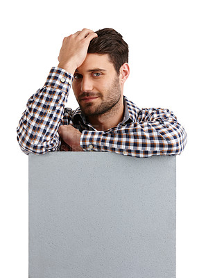 Buy stock photo Studio portrait of a handsome young man leaning on a blank placard isolated on white