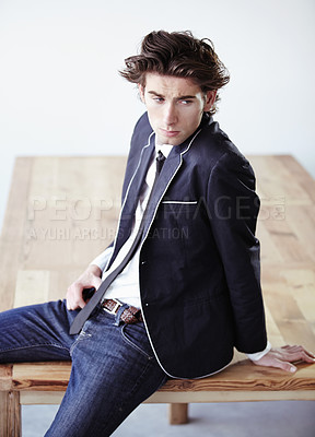 Buy stock photo Fashion, table and attractive man in a studio with formal, classy and elegant outfit for aesthetic. Handsome, suit and serious young male model with trendy and cool style for clothes by wooden desk.