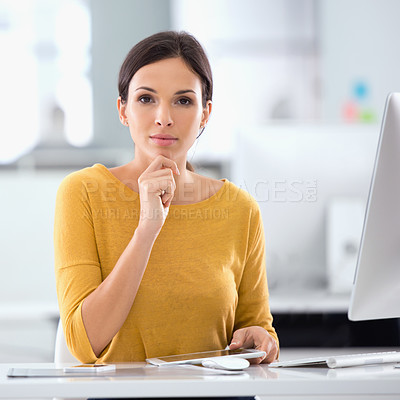 Buy stock photo Shot of an attractive businesswoman sitting at her desk in an office