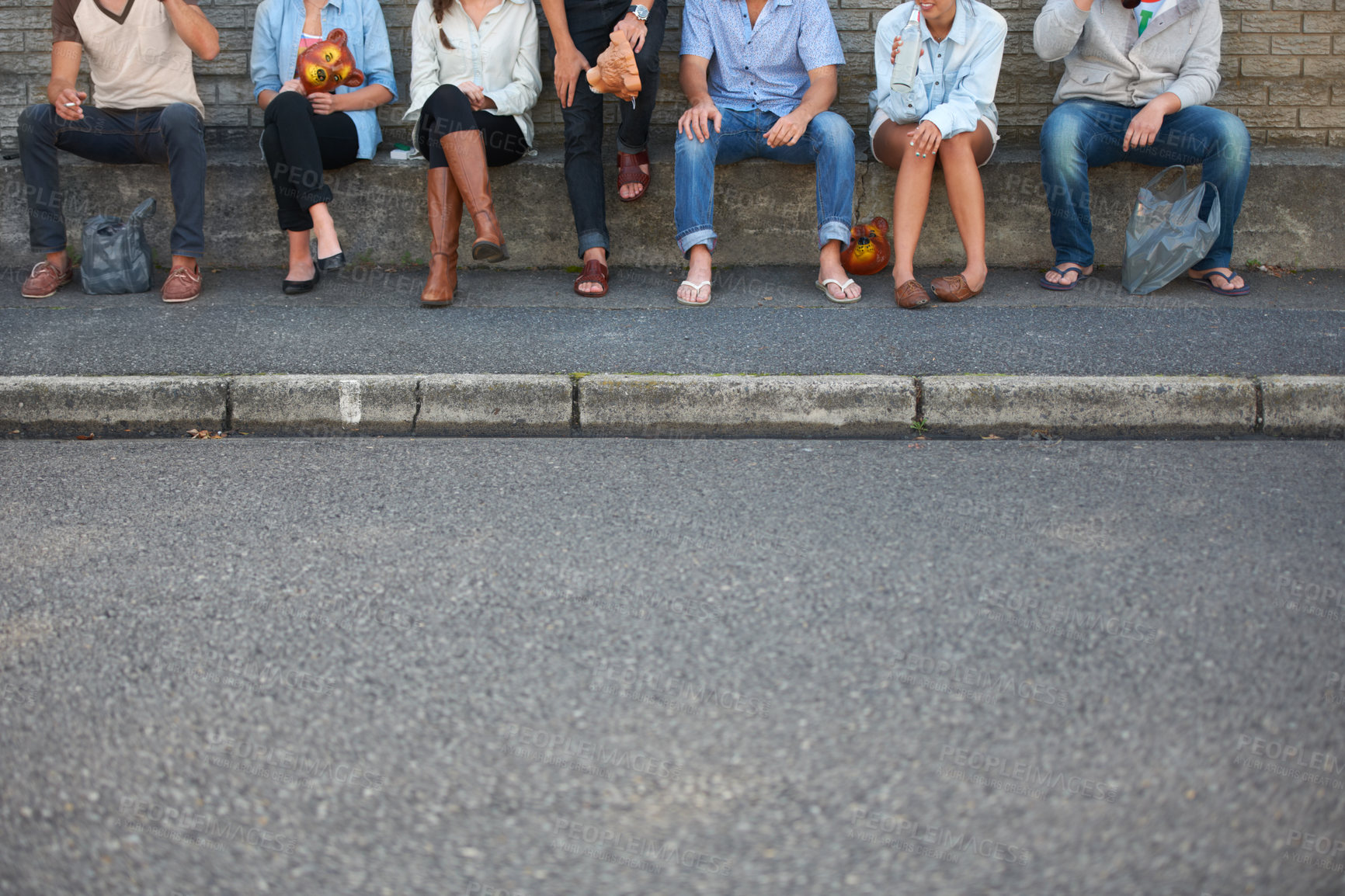 Buy stock photo Low, street and legs of people in the city for bonding, social and community event. Urban, together and friends or a group sitting on the sidewalk of the road for solidarity, party or society