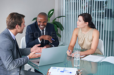 Buy stock photo Shot of a group of businesspeople sitting with a laptop and paperwork in a meeting