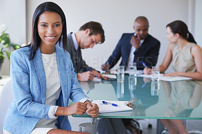 Buy stock photo Portrait of a young businesswoman with her colleagues having a meeting in the background