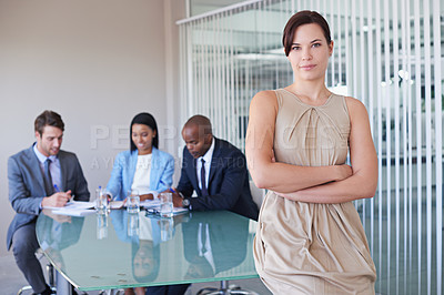 Buy stock photo Portrait of a confident businesswoman with her colleagues working in the background