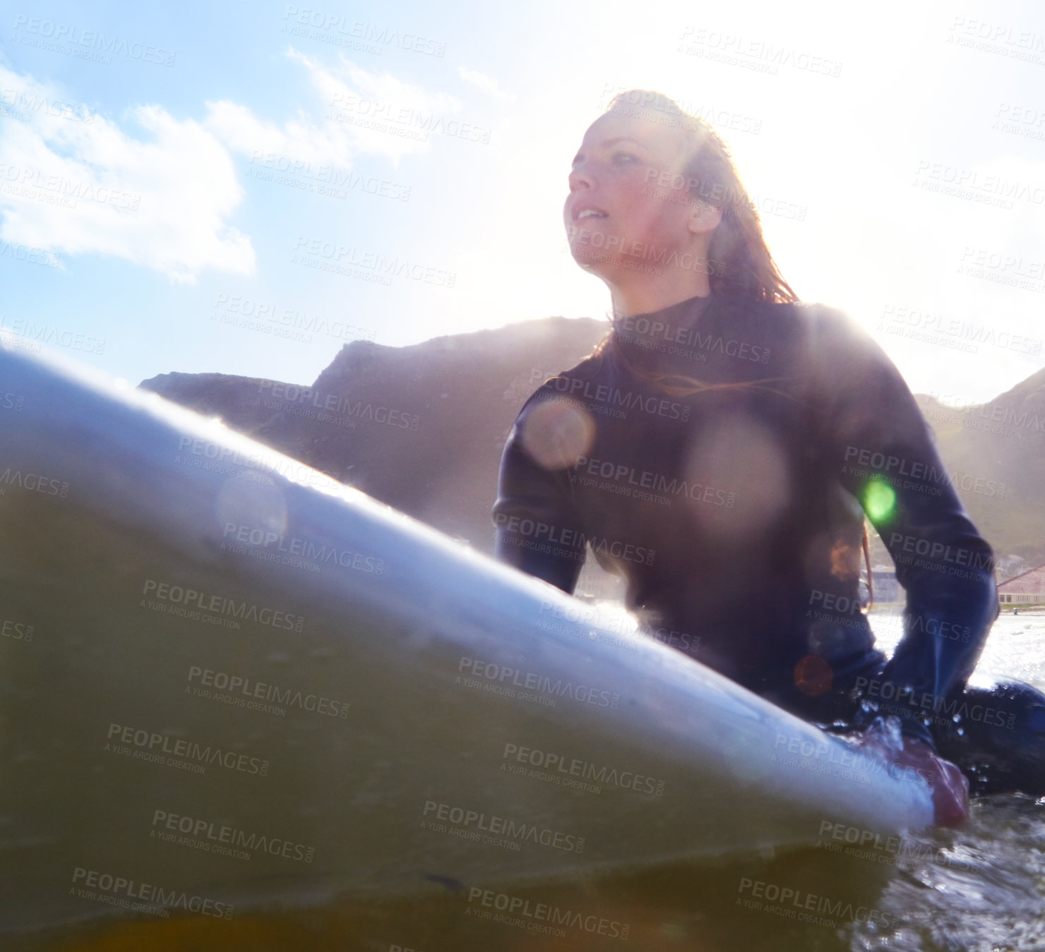 Buy stock photo Shot of a young woman on her surfboard in the sea