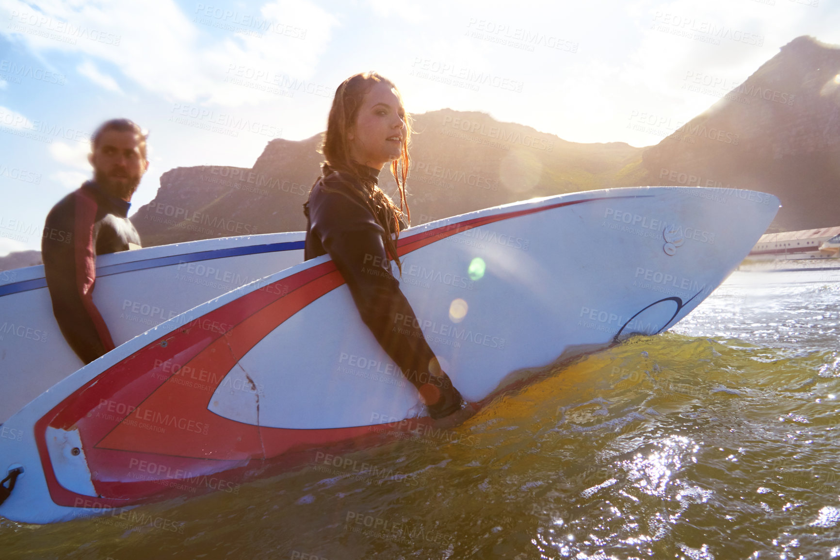 Buy stock photo Shot of an athletic young couple surfing at their favourite beach