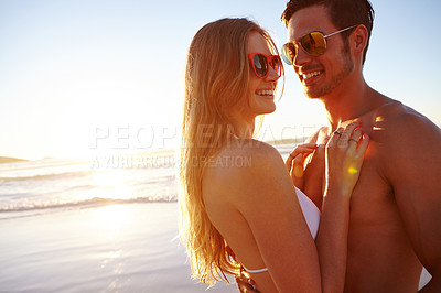 Buy stock photo Shot of a young couple enjoying a romantic moment at the beach