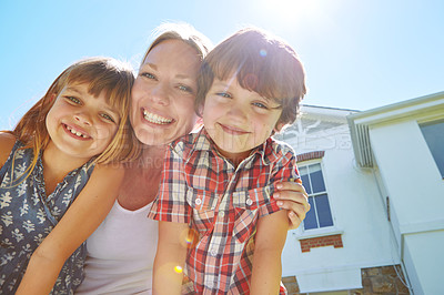 Buy stock photo Shot of a happy family of three enjoying a sunny day in their backyard