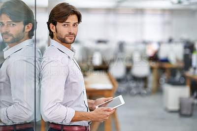 Buy stock photo Portrait of a handsome young businessman standing in his office holding a tablet