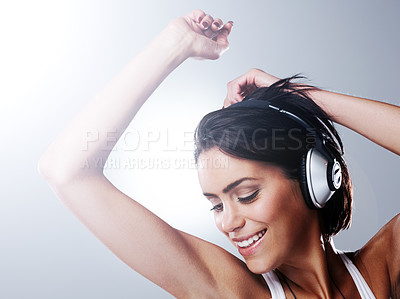 Buy stock photo Woman, music and fun dancing with confidence, freedom and excited with smile and casual fashion in studio. Young student and happy with audio and joy with grey background and carefree from party song