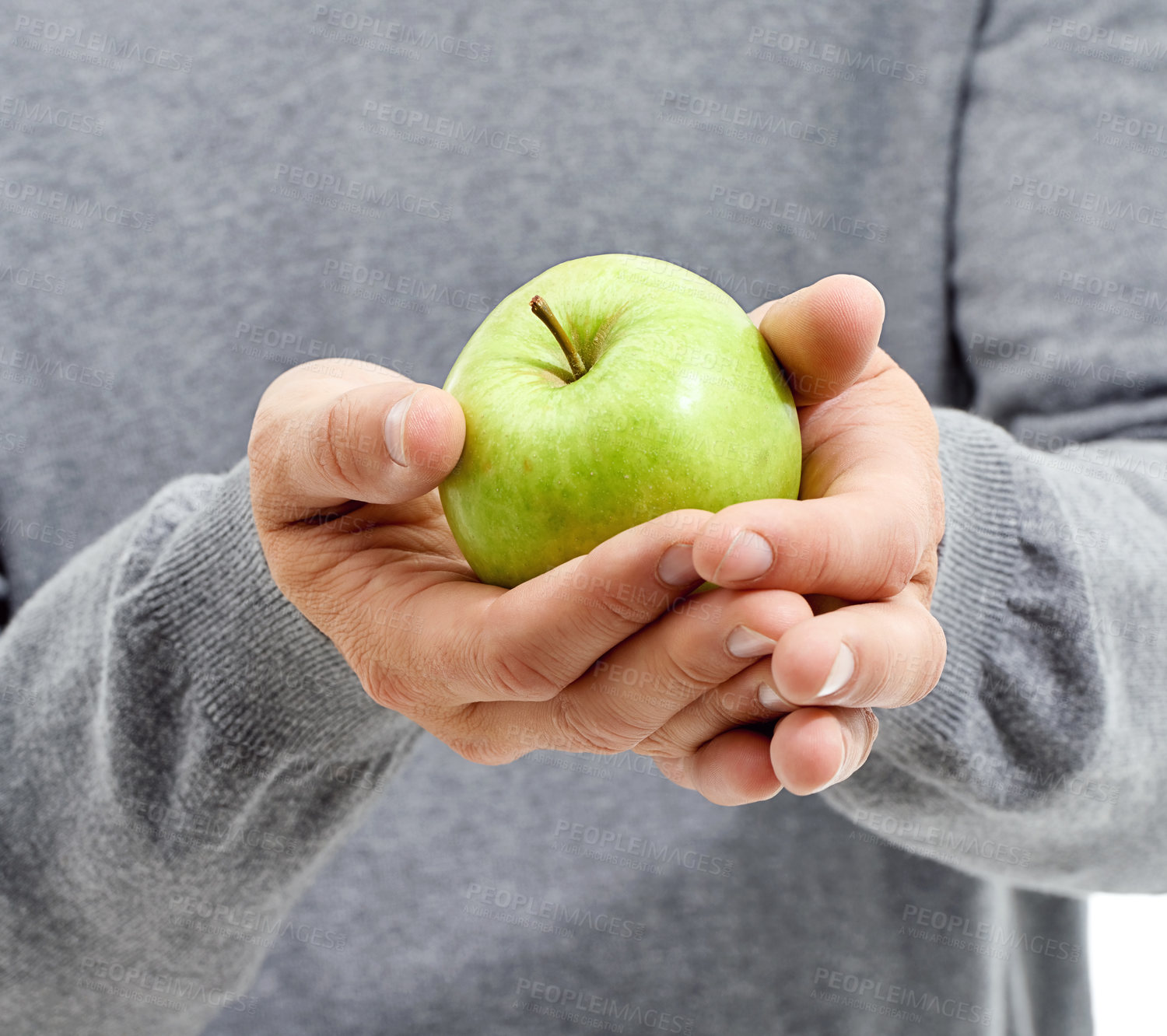 Buy stock photo Hand, health and man in a studio with a apple for nutrition, diet and a healthy snack with vitamins. Wellness, natural and healthy male person with fresh, organic and raw green fruit for a craving.