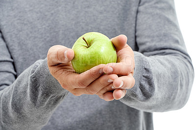 Buy stock photo Hand, wellness and male in a studio with a apple for nutrition, diet and a healthy snack with vitamins. Health, natural and healthy man or person with fresh, organic and raw green fruit for a craving