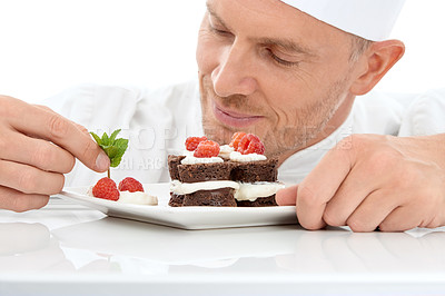 Buy stock photo Baking, presentation and chef with cake for dessert isolated on a white background. Cooking, professional and man plating a sweet treat and fruit on a plate for fine dining service at a restaurant