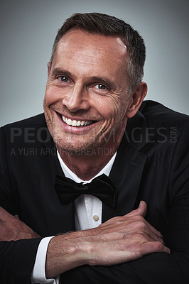 Buy stock photo Happy, portrait and man in a tuxedo in studio for a luxury valentines day, anniversary or romantic date. Happiness, smile and mature male model or gentleman in elegant formal suit by gray background.