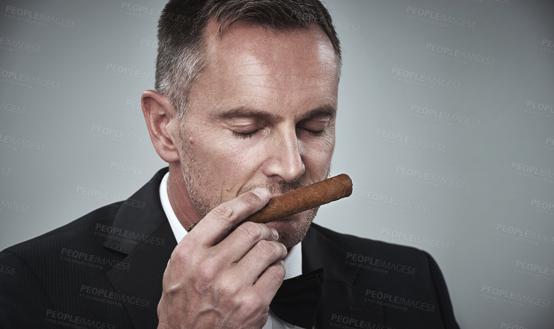 Buy stock photo Suit, luxury and man smell cigars for smoking habit on gray background for mafia, power and success mockup. Mafia, business gangster and face of senior male with cigarette for smoke, relax and calm