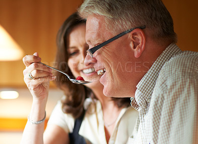 Buy stock photo Taste, senior or happy couple kitchen cooking with healthy food for lunch or dinner together at home in Sydney. Spoon, smile or woman eating with mature husband with love, care or meal in Australia