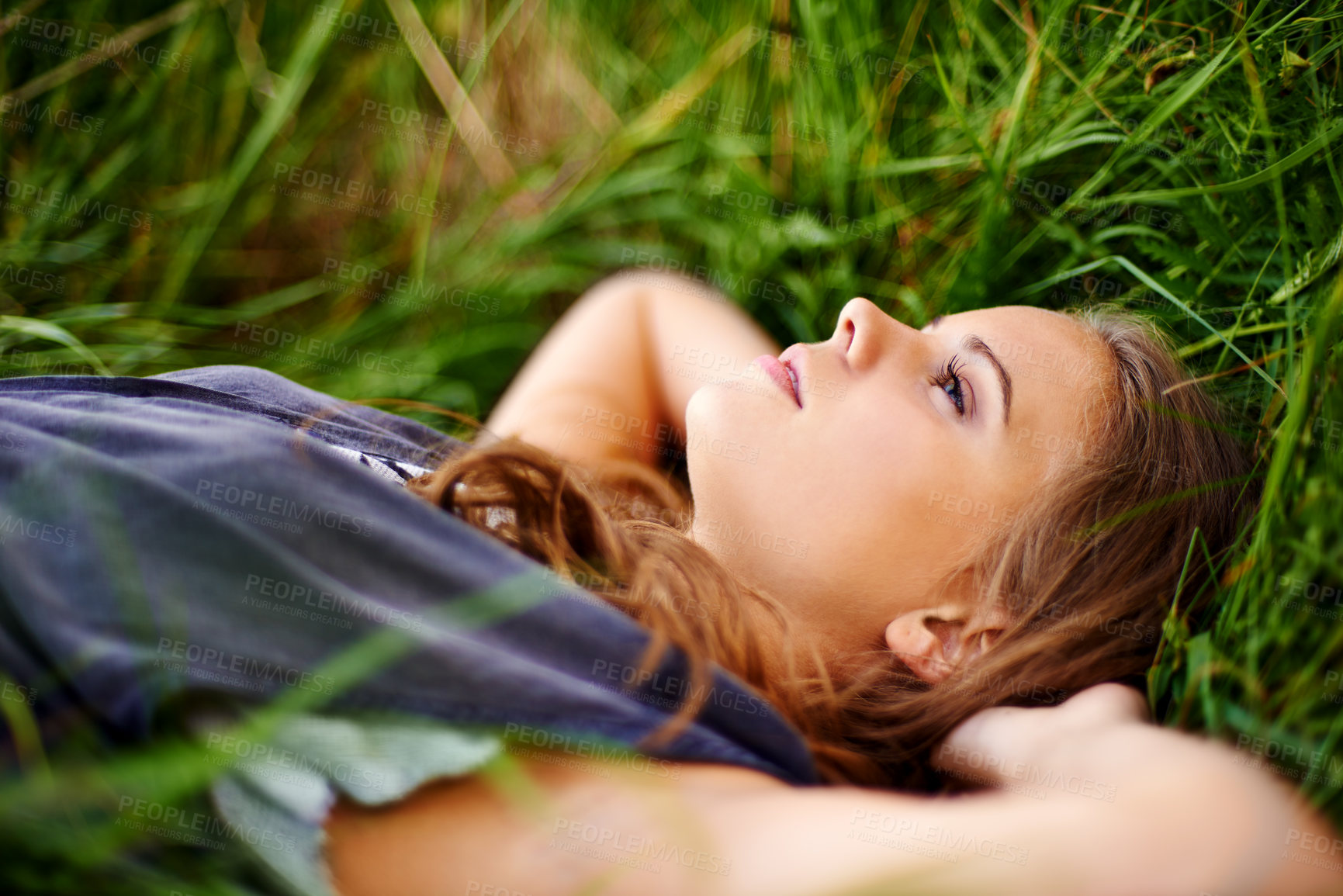 Buy stock photo Portrait of a beautiful woman lying in the grass