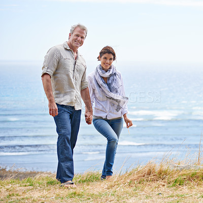 Buy stock photo Happy, mature couple and portrait of holding hands at the sea, ocean or walk on the beach in retirement. Summer, vacation or holiday with old man and woman together with love and support in marriage