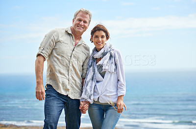 Buy stock photo Couple, portrait and holding hands at beach for holiday at sea, ocean or walk in summer. Happy, man and woman with support, love and care together or travel on vacation with freedom in marriage