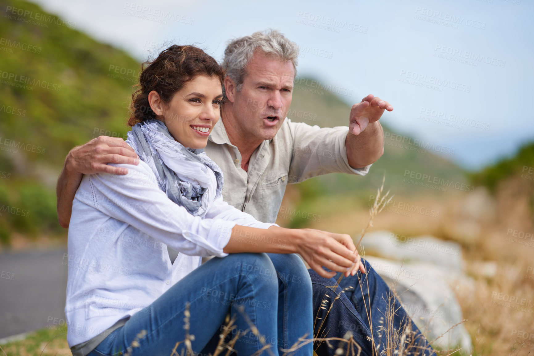 Buy stock photo Mature, couple and pointing at nature on holiday, vacation or embrace with love or support in marriage. Happy, woman and man together sightseeing on hill, mountain or relax in environment adventure
