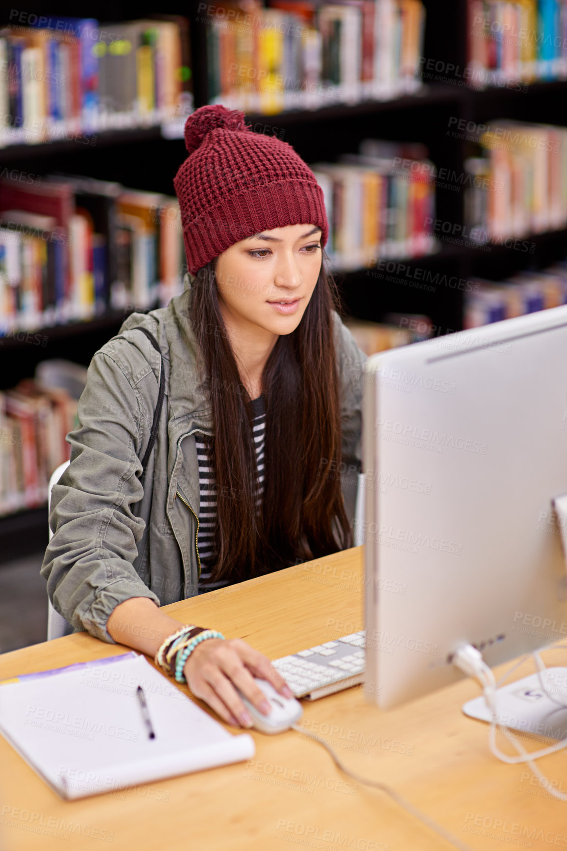 Buy stock photo Shot of a female student working on a computer in a university library