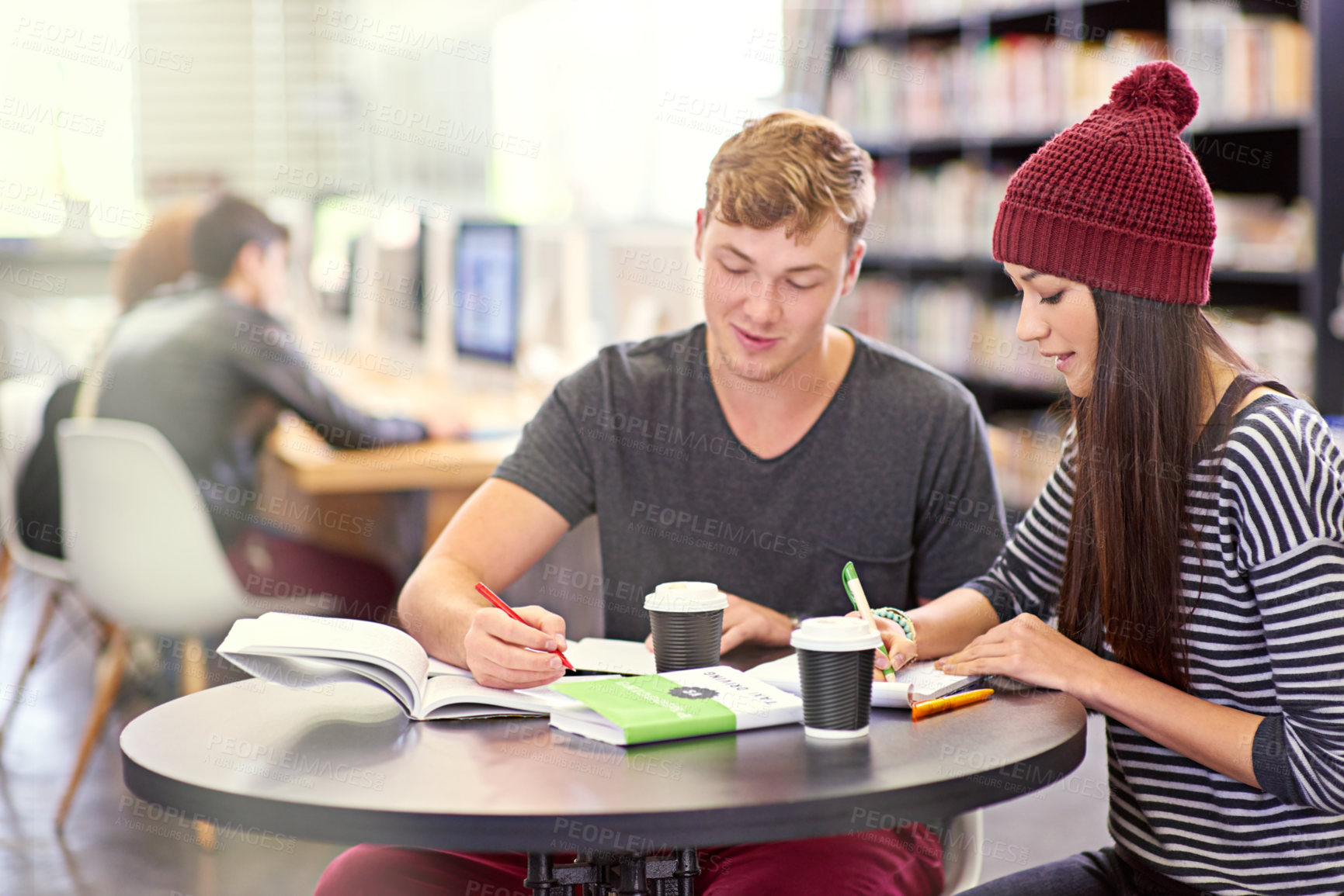 Buy stock photo Shot of two college students studying together at the library