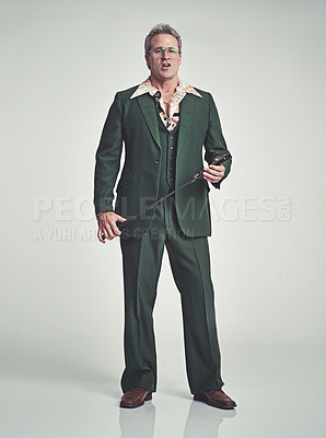 Buy stock photo Mature, man and serious with fashion in studio, suit and grey background with riding crop. Tuxedo, elegance and retro with unique style and formal in expensive clothes, classy and fashionable