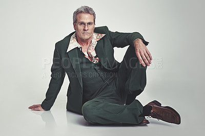 Buy stock photo Portrait, fashion and senior man in relax with style or business outfit on a gray studio background. Mature, male person or model posing and sitting on floor in formal clothing on mockup space
