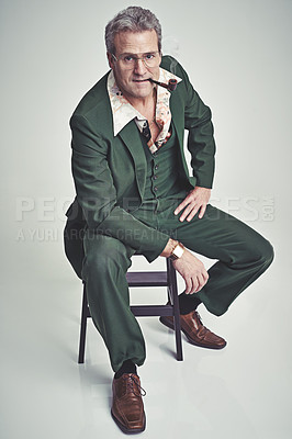 Buy stock photo Studio shot of a mature man in a retro suit lying down and striking a pose