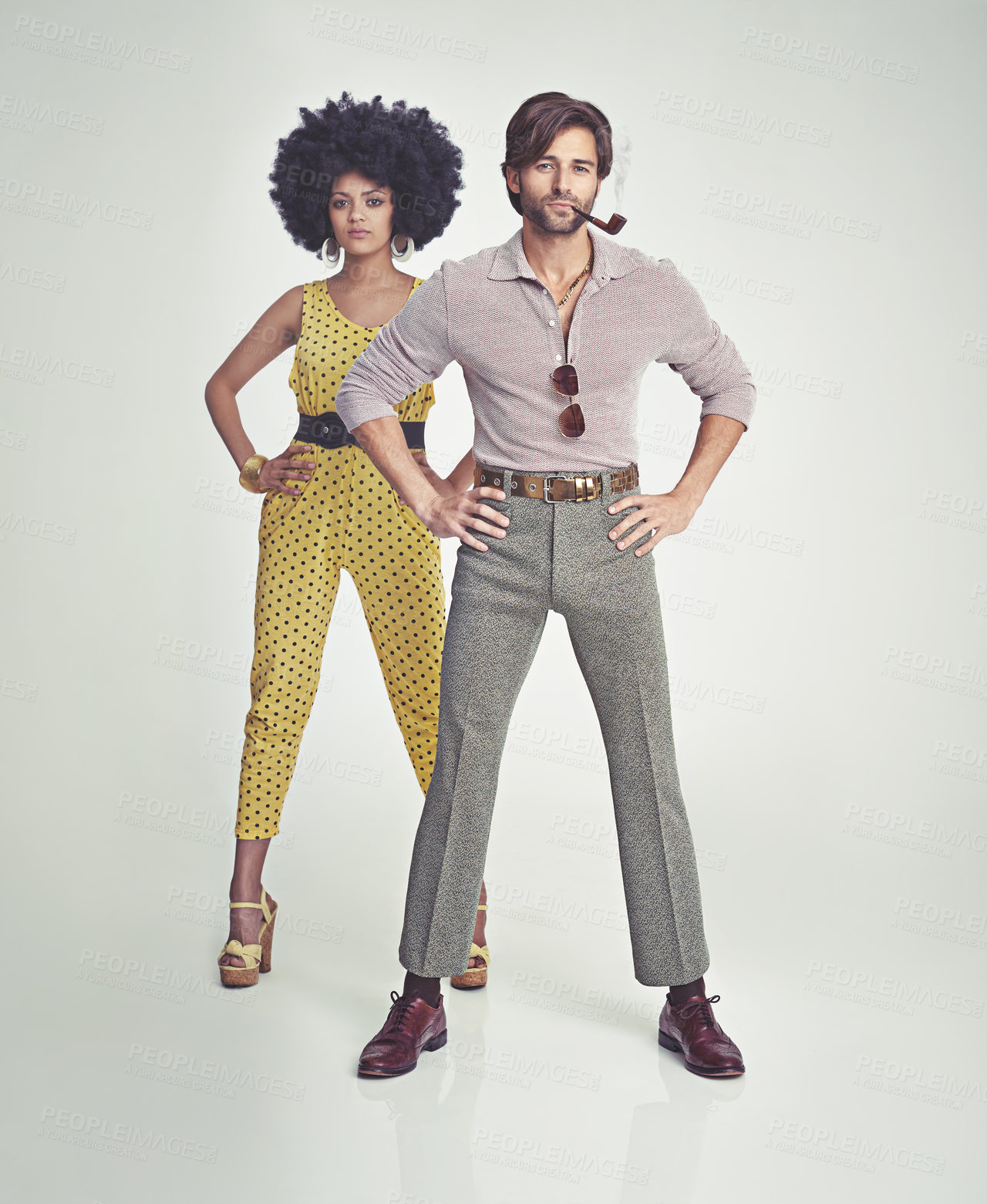 Buy stock photo Couple, portrait and fashion in confidence with pipe for smoking, style or outfit on a gray studio background. Interracial man, woman or smoker in stylish retro and vintage pants, shirt or jumpsuit