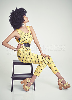 Buy stock photo A young woman wearing a 70s retro jumpsuit while in the studio