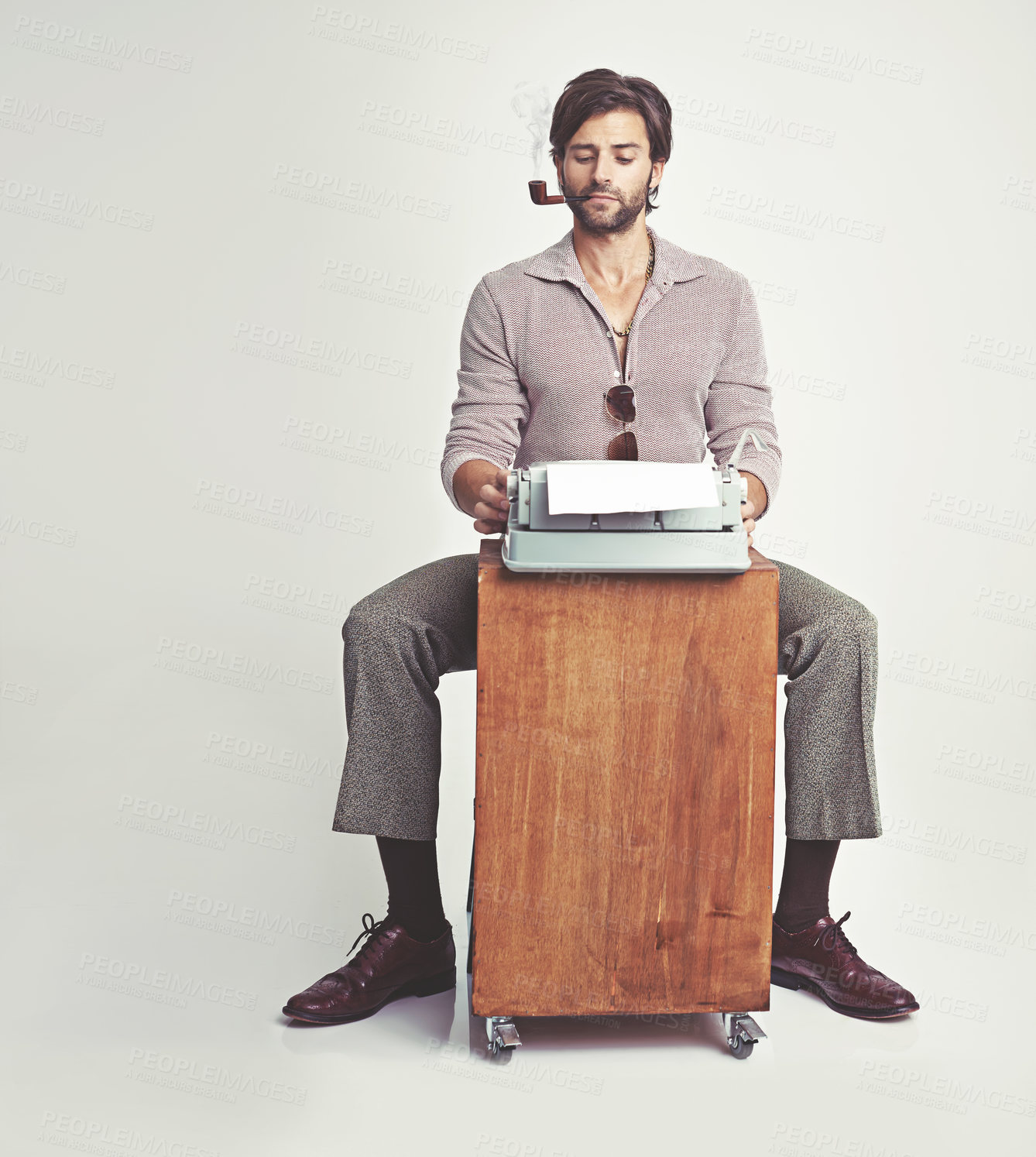 Buy stock photo Fashion, man and typewriter or smoking in studio with vintage model, hipster outfit and confidence on mockup. Relax, person and reading with 70s style, calm expression and pipe with white background