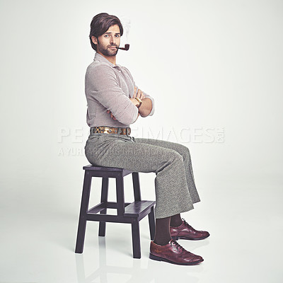 Buy stock photo A young man with 70s style sitting in the studio and smoking a pipe