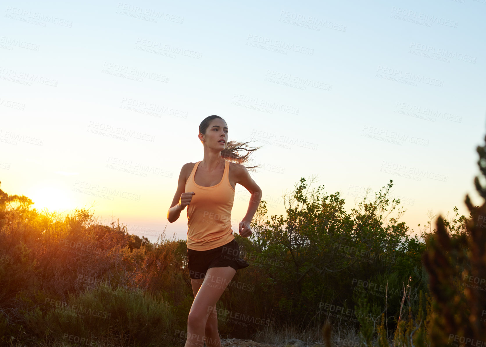 Buy stock photo Cropped shot of a young woman jogging outdoors