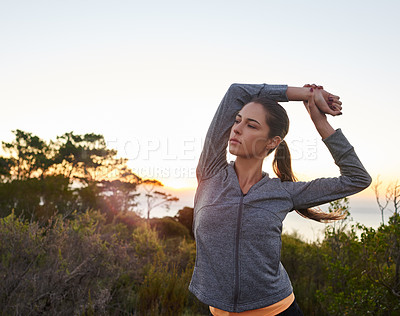 Buy stock photo Shot of a young woman warming up before her run