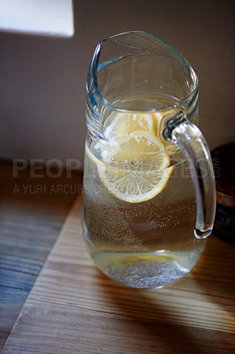 Buy stock photo Water, lemon and jug in kitchen for health benefits or detox drink for hydration or natural vitamins, organic or counter. Beverage, fruit and glass in home for antioxidants, vitamin c or immunity