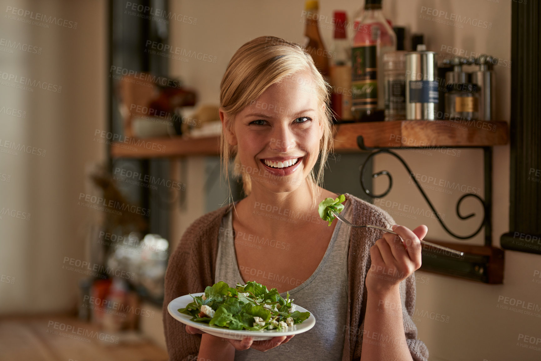 Buy stock photo Portrait, happy woman and eating salad in kitchen at home, nutrition and leafy greens for healthy diet. Vegetables, bowl and face of hungry person with food, fork and organic vegan meal for wellness