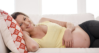 Buy stock photo Portrait of a young pregnant woman lying on her living room sofa