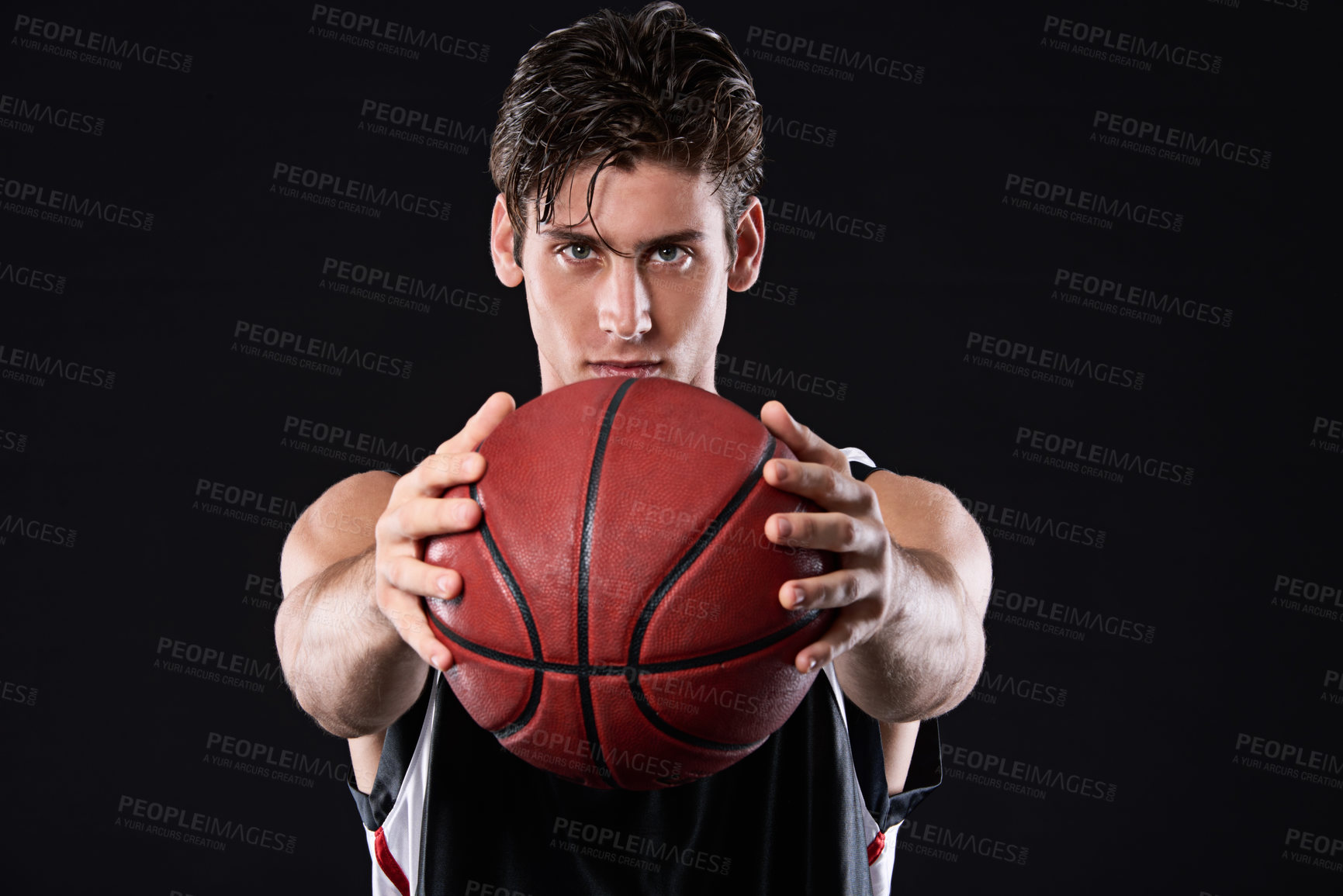 Buy stock photo Cropped studio portrait of a determined basketball player holding the ball out in front of him