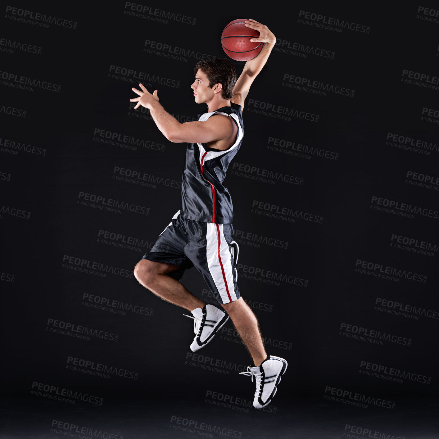 Buy stock photo Full length profile shot of a young male basketball player in action against a black background