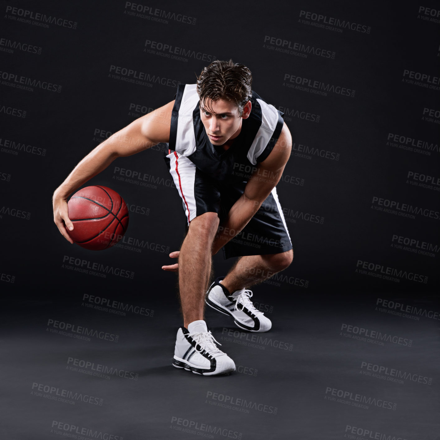 Buy stock photo Full length shot of a male basketball player in action against a black background