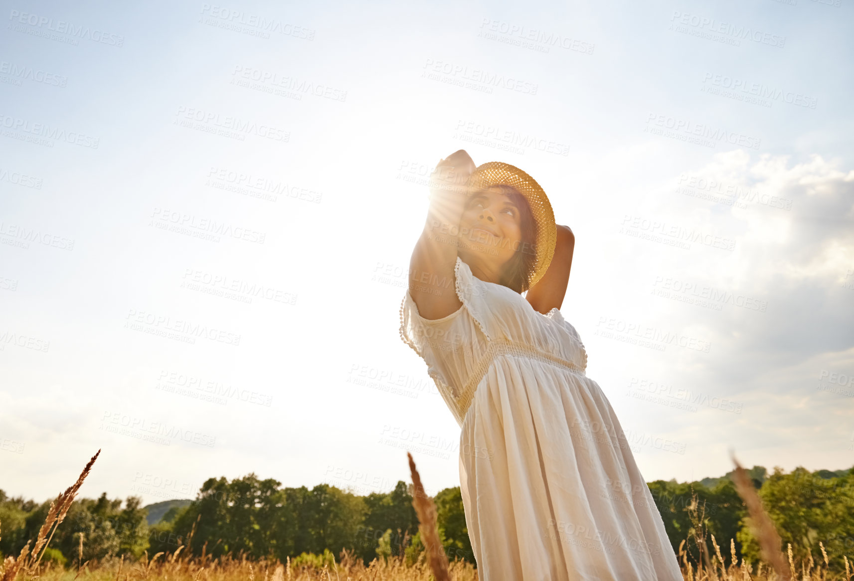 Buy stock photo Thinking, relax and woman with sunshine, countryside and nature with grass, vacation and outdoor. Person, holiday and girl with lens flare, dress and sustainability with confidence, energy or freedom