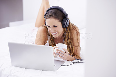 Buy stock photo Woman, bedroom and coffee on laptop for listening, watching and video streaming in headphones at home. Young person relax on bed with computer for morning news, social media or happy audio or podcast