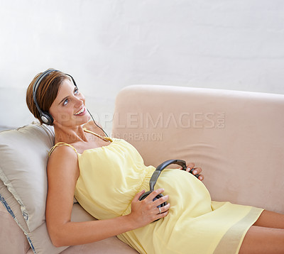 Buy stock photo Happy woman, music or headphones on pregnant stomach in house living room for sound, audio or baby listening development. Relax, pregnancy or person with childcare wellness or growth podcast support