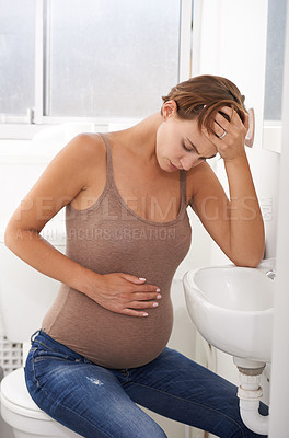 Buy stock photo Pregnant, woman and bathroom on toilet with stomach, pain and distress in labor or cramps. Female person, anxiety and discomfort in home with tired, mental health and wellness as mother in prenatal