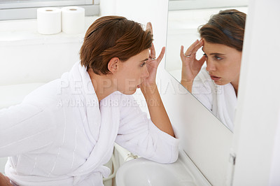 Buy stock photo Woman, mirror and headache pain in bathroom for morning sickness or hangover, reflection or fatigue. Female person, hand and nauseous problem for pregnancy in home with bathrobe, migraine or sore