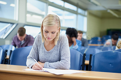 Buy stock photo Writing, woman and student with knowledge, education and learning with text, concentration and development. Female person, academic or group in a classroom, examination and innovation with a document