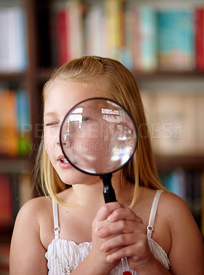 Buy stock photo Search, portrait and a child with a magnifying glass in a library for education, learning or inspection. Looking, young detective and a girl, kid or student with equipment for studying or attention